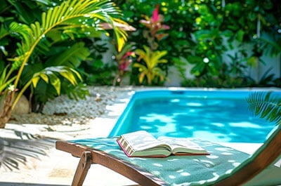 Book sitting on a lounge chair in a tropical lanai area