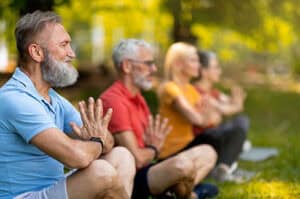 Group of seniors practicing yoga and meditation in the park